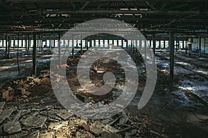 Abandoned large industrial hall or warehouse with garbage, ruined factory