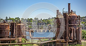 Abandoned machines and storage units in a gas industry at gas works park Seattle with homes behind