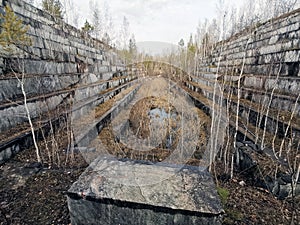 An abandoned marble quarry. Autumn landscape with a view of the overgrown steps of the old quarry.