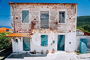 Abandoned Mediterranean house on the top of the green hill in the middle of Greek island