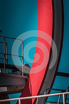 Abandoned metal diving structure. Iconic industrial and sports architecture, white and red steel elements on a deep blue clear sky