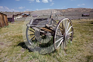 Abandoned mining equipment cart and buildings in the ghost town of Bodie, a California State Historical Park