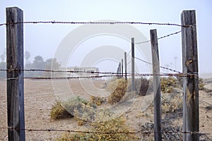 Abandoned mobile home with barb wire fence