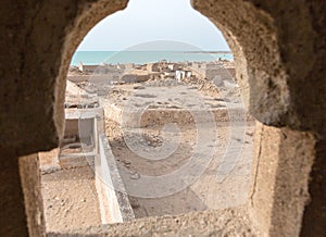 Abandoned mosque with minaret. Deserted village. A view out of minaret`s window to the sea. Al Jumail, Qatar.