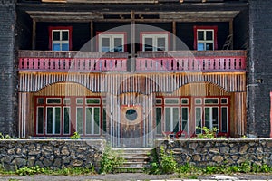 An abandoned motel made out of wood with red accents