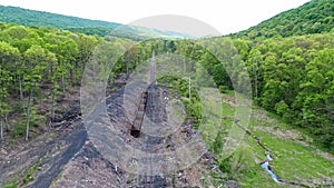 Abandoned Narrow Gauge Coal Rail Road with Rusting Hoppers and Freight Cars and Support Building