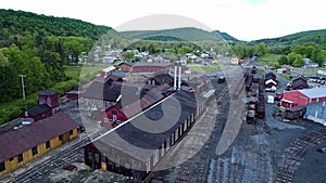 Abandoned Narrow Gauge Coal Rail Road with Rusting Hoppers and Freight Cars and Support Building Starting to be Restored