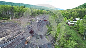 Abandoned Narrow Gauge Coal Rail Road with Rusting Hoppers and Freight Cars and Support Building Starting to be Restored