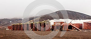 Abandoned norwegian whale hunter station rusty blubber tanks panorama at Deception island, Antarctic