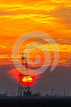 Abandoned oil and gas rig profiled on dramatic evening sky
