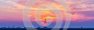 Abandoned oil and gas rig profiled on dramatic evening sky