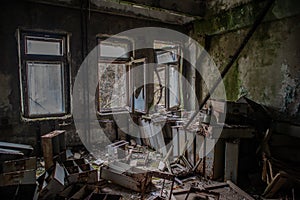 Abandoned, old. creepy, dark, ruined room with furniture covered in moss in the building located in the Chernobyl ghost town