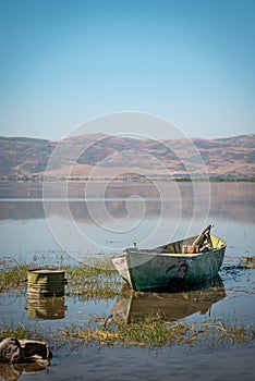 Abandoned old fishing boat in the lake that started to dry up and recede due to global warming