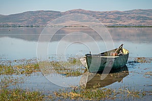 Abandoned old fishing boat in the lake that started to dry up and recede due to global warming