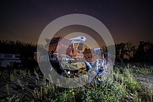 Abandoned old harvester at night