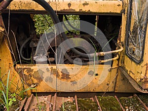 Abandoned old rusty bulldozer with diesel motor and hydraulic hose, vintage industrial heavy machine, earthmover equipment,