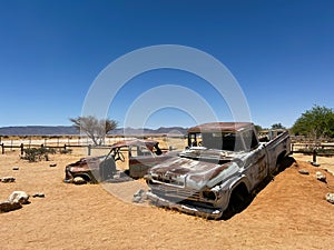 Abandoned old rusty car. Body of a retro car in the sands. Desert in Namibia.