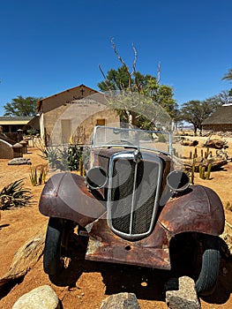 Abandoned old rusty car. Body of a retro car in the sands. Desert in Namibia.