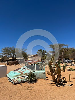 Abandoned old rusty car. Body of a retro car in the sands. Desert in Namibia.