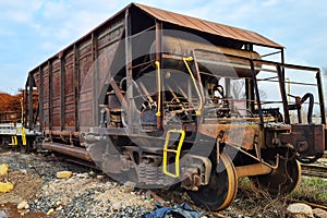 Abandoned old rusty freight industrial wagon on a factory railroad at sunny day