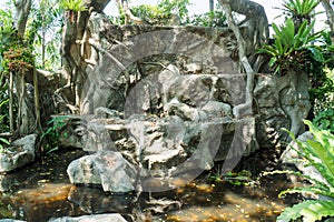 Abandoned old stone waterfall in public park background. Deserted rock waterfall in the garden