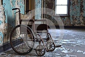 An abandoned old wheelchair sits in a room with peeling paint, showcasing the passage of time and neglect, An old rusty wheelchair