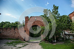 Abandoned and overgrown gateway of red brick to former Kikin Ermolov`s manor, Ryazan region, Russia