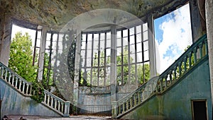 Abandoned and overgrown interior of old mansion .