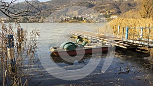 Abandoned pedal boats at the pier in the reeds on the shore of the lake. Autumn season