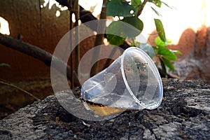 Abandoned plastic bowl in a vase with stagnant water inside. close up view. mosquitoes in potential breeding.proliferation of