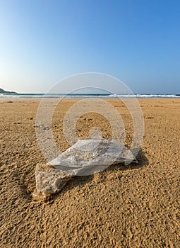 Abandoned plastic polythene bag on the beach.
