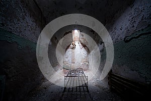 Abandoned prison cell with a old bed frame