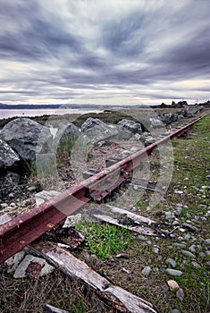 An Abandoned Railroad Track Rusts Under Stormy Skies