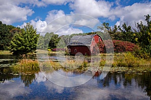 An abandoned red sinking barn sinks into a lake near Zimmerman, MN in rural minnesota