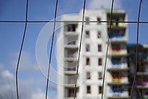 Abandoned residential building, close-up on a fence, defocused background - bokeh effect