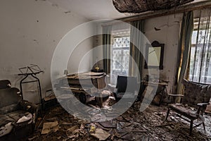 abandoned room with a piano and a armchair