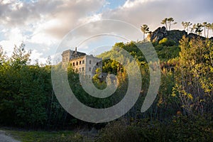 Abandoned ruin building of Termas Radium Hotel Serra da Pena in Sortelha with beautoful colorful trees at sunset, Portugal photo