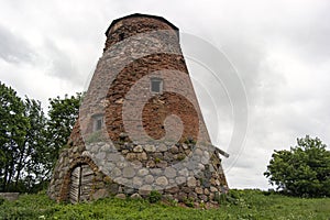 Abandoned ruin of old windmill tower near the city.