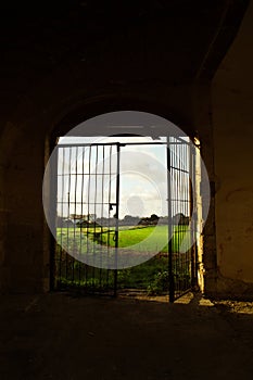 Abandoned Ruin in Southern Italy with Open Gate and Scenic Italian Landscape Beyond