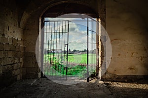 Abandoned Ruin in Southern Italy with Open Gate and Scenic Italian Landscape Beyond
