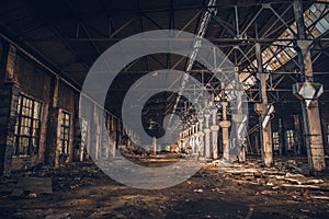 Abandoned and ruined dark industrial creepy warehouse inside with columns, corridor or tunnel view, old grunge factory building