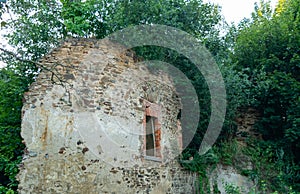 Abandoned ruins of a medieval building outgrown with plants