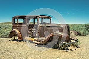 Abandoned Rusted antique car near painted desert on Route 66