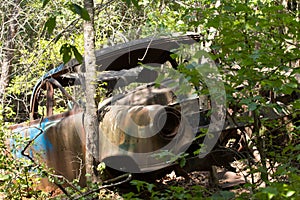 Abandoned rusted car in the woods