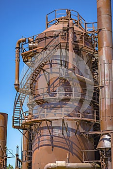 Abandoned rusted machines and storage units in a gas industry at