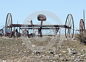 Abandoned, rusting vintage farm equipment in an open field