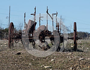 Abandoned, rusting vintage farm equipment in an open field