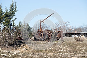 Abandoned, rusting vintage farm equipment in an open field