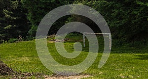 Abandoned rusty football goal in meadow