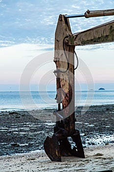 Abandoned rusty and old excavator on the beach view